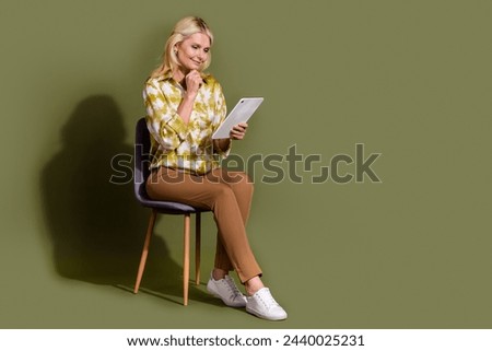 Full length photo of elderly female data researcher curious using wireless device pad surfing news isolated on khaki color background