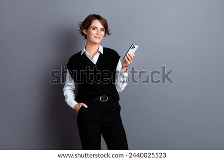 Photo of charming adorable pretty lady wearing trendy clothes holding apple iphone standing empty space isolated on gray color background