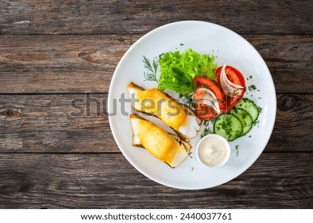 Seared halibut and fresh vegetables on wooden table 