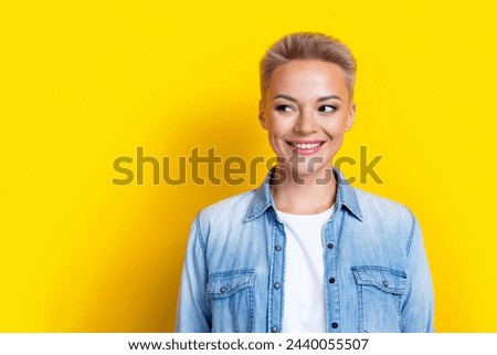 Photo portrait of pretty young girl look empty space promo wear trendy jeans outfit isolated on yellow color background