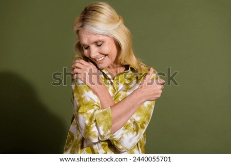 Portrait of comfort hugging blonde hair retired positive woman embrace herself relaxed satisfied glad isolated on khaki color background Royalty-Free Stock Photo #2440055701