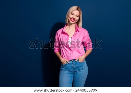 Photo of confident nice woman with bob hairstyle dressed pink shirt holding palms in jeans pockets isolated on dark blue background