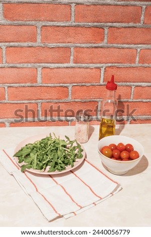 Harvested arugula on a pink plate in a kitchen marble table. Food ingredients concept