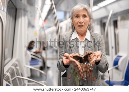 European lady can't find her belongings because they're was stolen from her handbag in subway train. Royalty-Free Stock Photo #2440063747