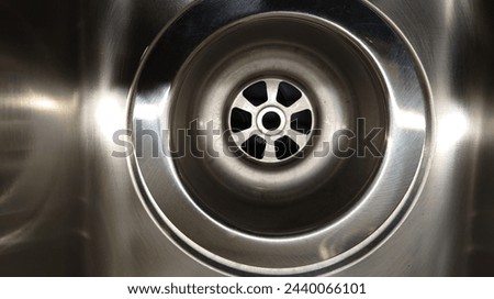 Close up of stainless steel sink with one circular sewer hole on the bottom, closeup of sink, top view, high resolution photography, professional color grading, soft shadows, no contrast, clean sharp 