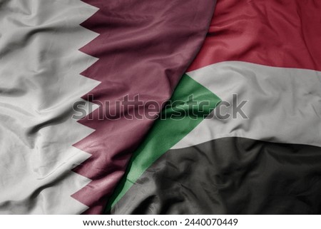 big waving national colorful flag of sudan and national flag of qatar. macro