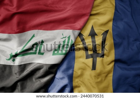 big waving national colorful flag of barbados and national flag of iraq. macro