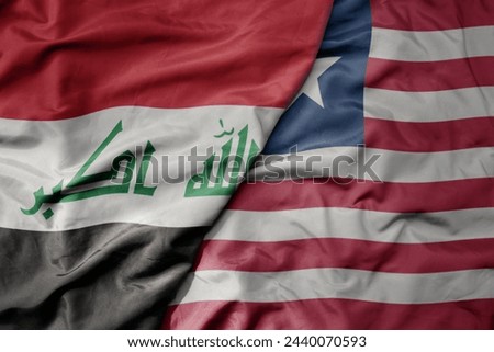 big waving national colorful flag of liberia and national flag of iraq. macro