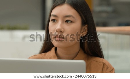 Close up pensive Asian woman working on laptop thinking solution chinese girl japanese korean student look away think plan search idea puzzled thoughtful businesswoman contemplate analyzing thoughts Royalty-Free Stock Photo #2440075513