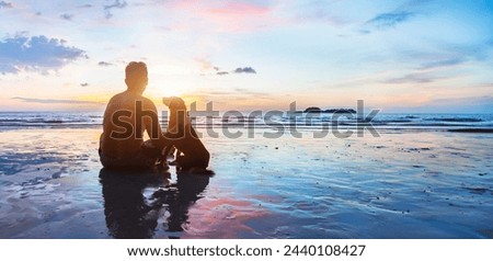 dog and human sitting together on the beach at sunset, friendship, silhouette of man with his dog, banner background with copyspace