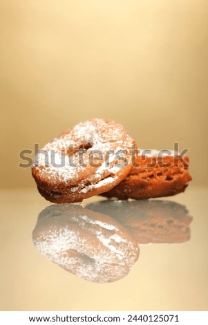 A picture of fresh home-made doughnut powdered sugar against light background