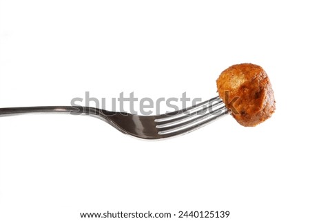A picture of traditional Swedish meatball on a fork over white background