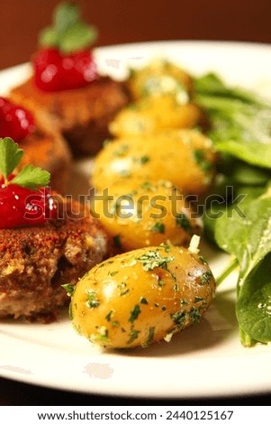 A picture of traditional Polish meatballs served with spring potatoes and spinach