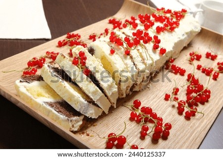 A picture of a Polish traditional cake with redcurrant presented on a wooden board
