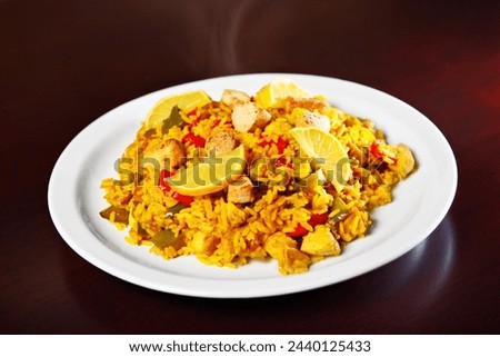 A picture of a fresh home made paella served on a white plate