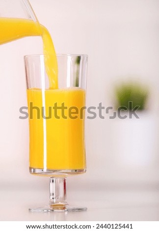 A picture of a glass of orange juice on the kitchen top