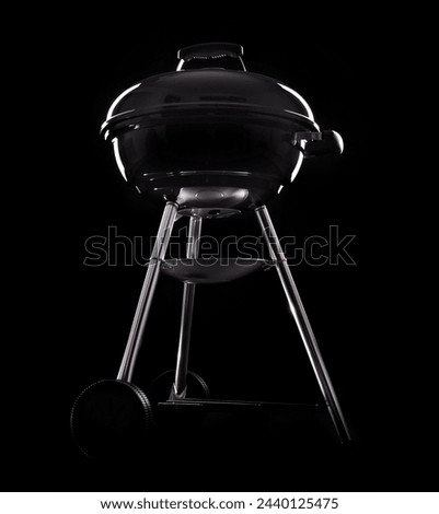 A picture of a new black barbecue over black background