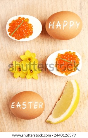 A picture of a composition of eggs and red caviar and flowers over natural background