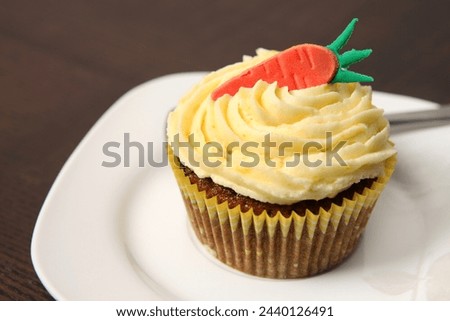 A picture of a carrot cupcake served on a white plate