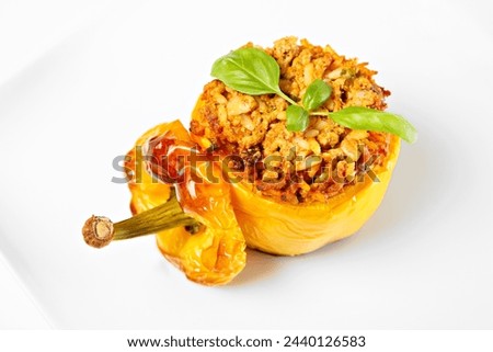 A picture of a yellow stuffed pepper baked and served on a white plate