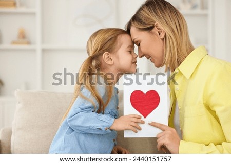 Little daughter congratulating her mom with greeting card at home, space for text. Happy Mother's Day