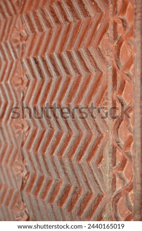 Chevron pattern carving in red sandstone. Intricate carvings at Fatehpur Sikri, India. Historic Mughal Indian architecture at Fatehpur Sikri Agra. Popular zigzag chevron grunge pattern background