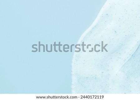 The texture of a scrub or shower gel on a blue background. Copy spase.