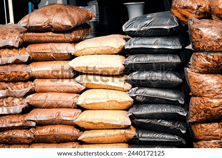 A pile of bags of different colored grains and beans. The bags are stacked on top of each other, Agriculture supply 