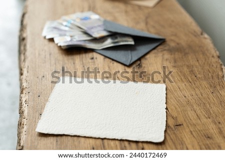 Concept of bequest of inheritance. White sheet of paper and money in an envelope in the background Royalty-Free Stock Photo #2440172469