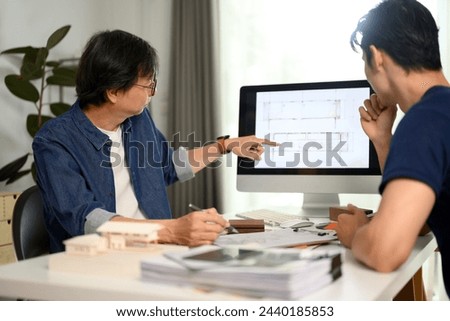 Professional architect man pointing on computer monitor discussing building plan design project with his client