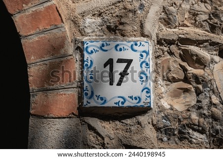 Vintage ceramic plaque with the number 17 on the facade of an ancient house - details of ancient architecture