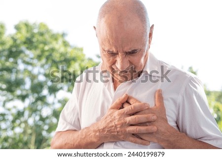 signs of myocardial infarction, senior, caucasian mature man 65 years old holds to heart, sudden chest pain, Arterial hypertension, Myocarditis or Arrhythmia, first aid Royalty-Free Stock Photo #2440199879