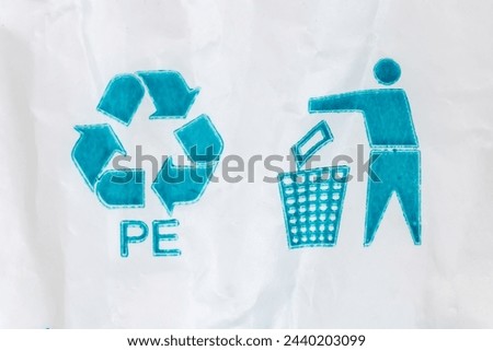 Blue universal recycling symbol with recycling code and tidy man symbol called to dispose encourage of packaging in the waste bin pictured on white polyethylene bag
