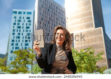  Smiling caucasian businesswoman with digital tablet outdoors.
