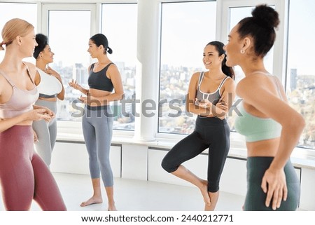 group of five joyful multicultural women standing in sportwear and chatting before pilates class Royalty-Free Stock Photo #2440212771