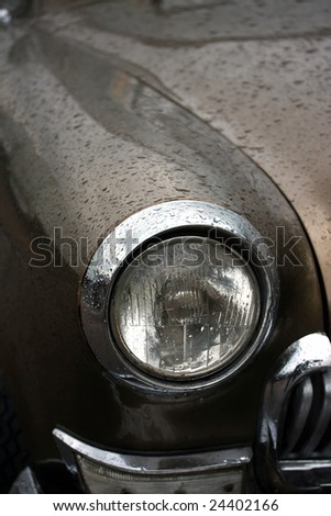 Headlight of the old car in the rain