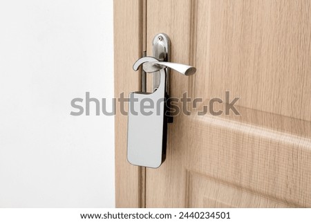 Light wooden door in hotel room with door hanger