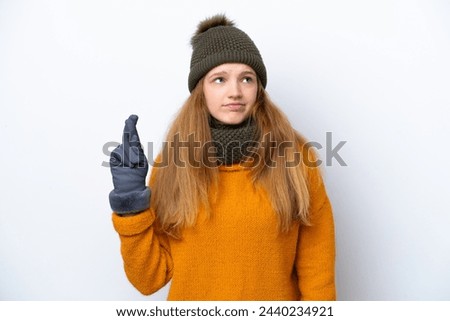 Teenager Russian girl wearing winter jacket isolated on white background with fingers crossing and wishing the best