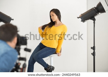 sultry female model posing during studio photo shoot Royalty-Free Stock Photo #2440249563