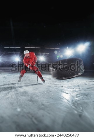 Ice hockey rink arena with professional player shooting the puck with hockey stick. Focus on 3D flying puck with blur motion effect.