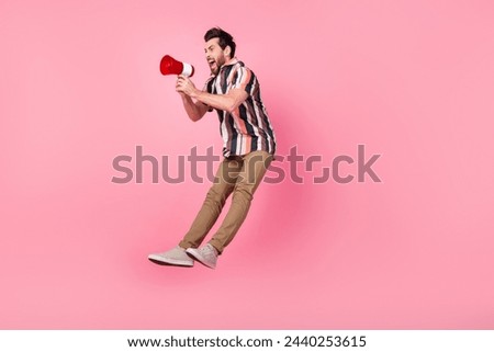 Full length size photo of crazy activist man with megaphone jumping announce protest against government isolated on pink color background Royalty-Free Stock Photo #2440253615