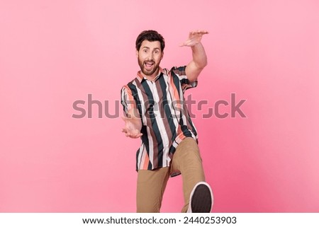 Photo of mature age positive man in striped shirt hands towards him dancing having fun discotheque isolated on pink color background