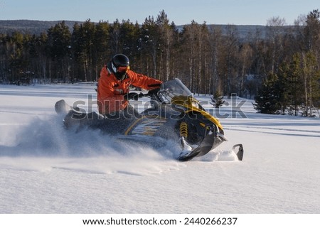 Athlete on a snowmobile moving in the winter forest in the mountains of the Southern Urals.