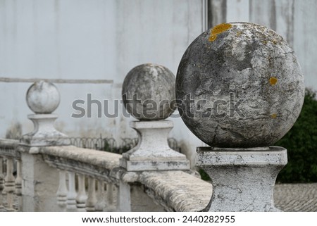 Spheres of granite placed on pillars on balcony railing in public park in Lisbon in Portugal