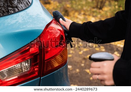 Closeup picture, image young woman, driver, dry wiping her car with microfiber cloth after washing it, cleaning auto, automobile windows. Transportation self service, care concept. Paint protection