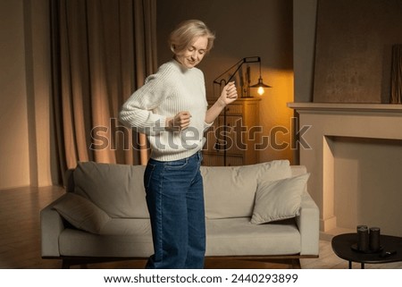 A person in a relaxed state enjoys a peaceful dance alone in the comfort of a warmly lit living room, subtly moving to an unheard rhythm, evidently finding joy in the simple pleasure of movement.