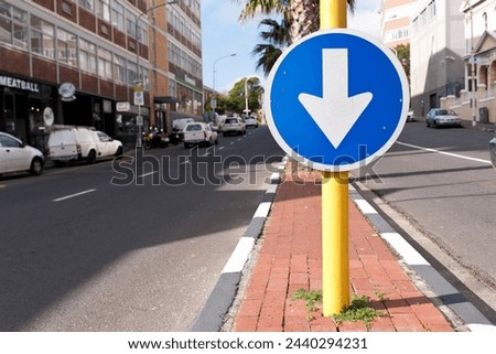 Road sign, blue arrow and signage in street for direction with attention notification and symbol outdoor in city. Board, public notice and signpost for driver, alert message and advertisement in town