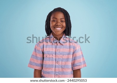 Boy, fashion and portrait of black child happy in studio with confidence, style or positive attitude on blue background. Face, smile or African teen model with good mood, clothes or outfit choice