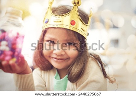 Candy, girl or princess with crown in portrait, home or castle with queen costume, sweets or royal tiara. Play, happiness or face of a child or kid with smile, development or fantasy game in a house