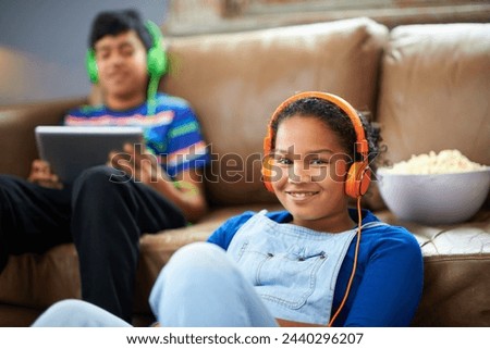 Tablet, children and portrait of girl with headphones in streaming, music or audio book with her brother at home. Kids, family and siblings in living room with digital, app or radio, relax or bonding